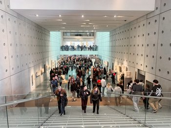 Crowded interior of the modern Acropolis Museum in Athens, Greece, with visitors on multiple levels and glass staircases, highlighting the popular free admission events for International Museum Day 2026.